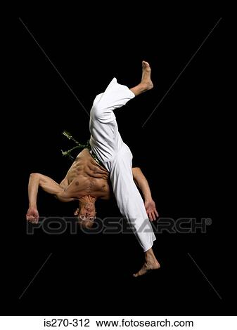 Stock Image - Man performing capoeira. Fotosearch
