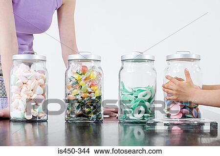 Picture - Child taking jar of sweets. Fotosearch