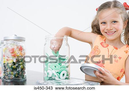 Girl taking sweets from a jar View Large Photo Image Stock Image - Girl taking sweets from a jar. Fotosearch