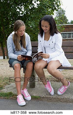Girls reading a magazine View Large Photo Image Stock Photo - Girls reading a magazine. Fotosearch
