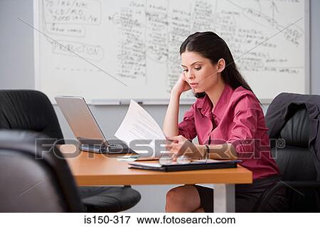 Stock Photo - Office worker reading paperwork. Fotosearch