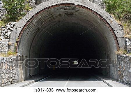Stock Image - Road going into a tunnel. Fotosearch