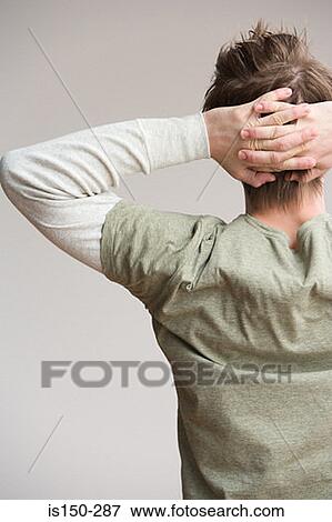 Stock Photo - Young man with hands behind head. Fotosearch