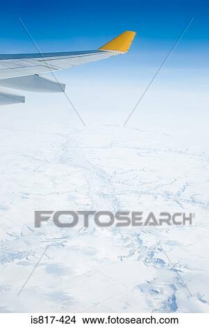 Picture - Aeroplane above snowy landscape. Fotosearch