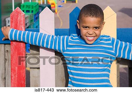 Boy leaning on fence View Large Photo Image Stock Image - Boy leaning on fence. Fotosearch
