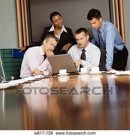 Businesspeople using a laptop computer View Large Photo Image Stock Photograph - Businesspeople using a laptop computer. Fotosearch