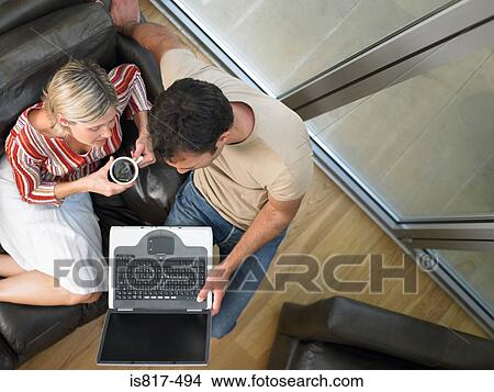 Picture - Couple on sofa with laptop. Fotosearch