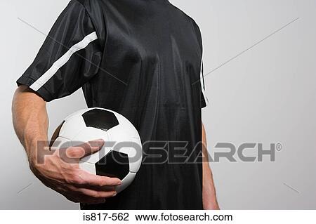 Stock Image - Footballer holding football. Fotosearch