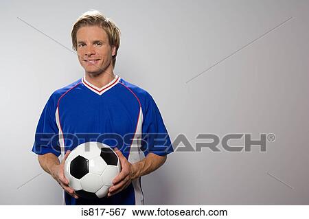 Stock Photo - Footballer holding football. Fotosearch