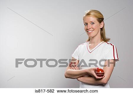 Stock Image - Woman holding cricket ball. Fotosearch