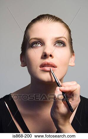 Stock Image - Woman having lip gloss applied. Fotosearch
