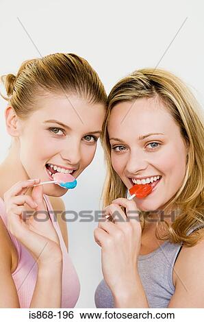Young women eating lollipops View Large Photo Image Stock Photograph - Young women eating lollipops. Fotosearch