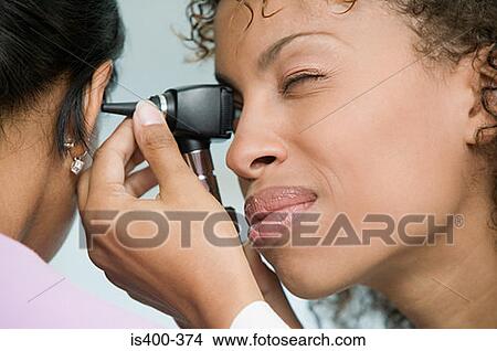 Doctor examining patient with otoscope View Large Photo Image Picture - Doctor examining patient with otoscope. Fotosearch