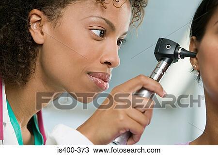 Doctor examining patient with otoscope View Large Photo Image Stock Image - Doctor examining patient with otoscope. Fotosearch