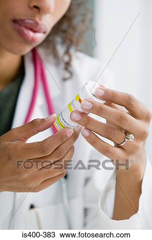 Doctor looking at medicine View Large Photo Image Stock Image - Doctor looking at medicine. Fotosearch