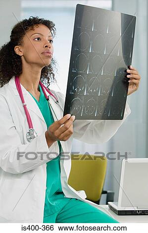 Doctor looking at mri scan View Large Photo Image Stock Photograph - Doctor looking at mri scan. Fotosearch