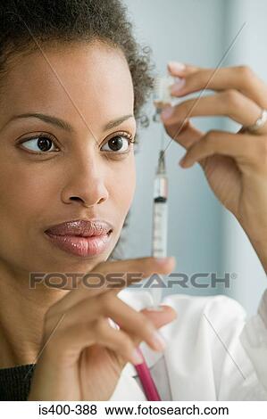 Doctor preparing syringe View Large Photo Image Stock Photo - Doctor preparing syringe. Fotosearch