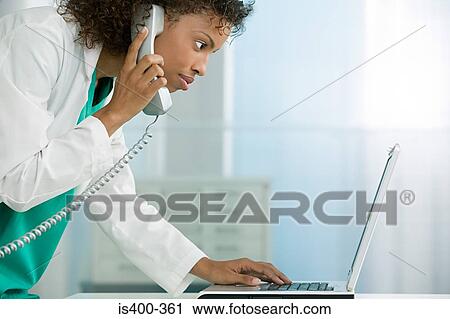 Doctor with telephone and laptop View Large Photo Image Stock Image - Doctor with telephone and laptop. Fotosearch
