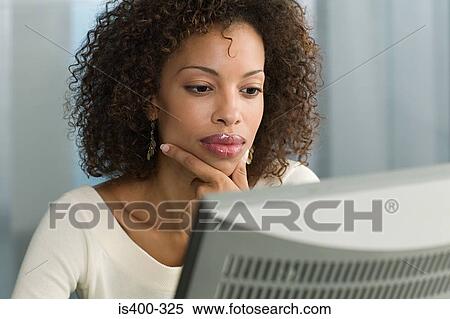 Stock Photography - Woman looking at computer. Fotosearch