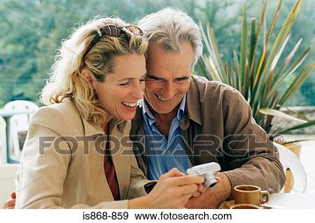 Stock Photo - Couple looking at digital camera. Fotosearch