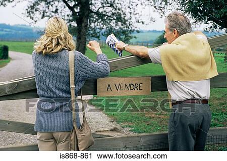 Stock Image - Couple looking at property for sale. Fotosearch