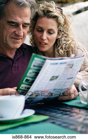 Picture - Couple looking at property magazine. Fotosearch