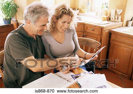 Stock Image - Couple with laptop and paperwork. Fotosearch