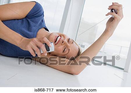 Stock Photo - Happy woman with two cellphones. Fotosearch