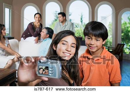 Stock Photo - Girl and boy with camera at family reunion. Fotosearch