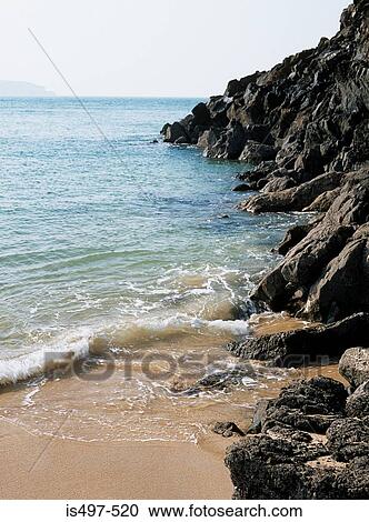 Rocky cliff onto beach View Large Photo Image Stock Image - Rocky cliff onto beach. Fotosearch