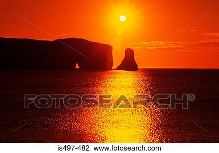 Stock Image - Sunrise over rocher perce quebec. Fotosearch