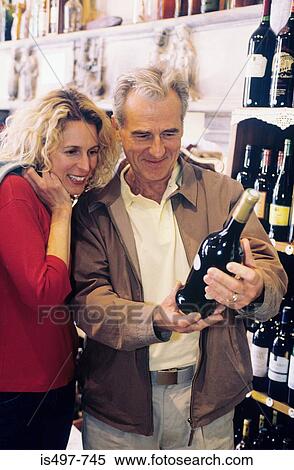 Stock Photography - A couple choosing wine. Fotosearch