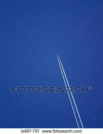 Stock Image - Airplane and a vapour trail. Fotosearch