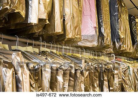 Stock Image - Dry cleaning hanging on a clothes rail. Fotosearch