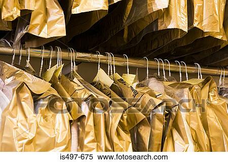 Stock Photography - Dry cleaning hanging on a clothes rail. Fotosearch