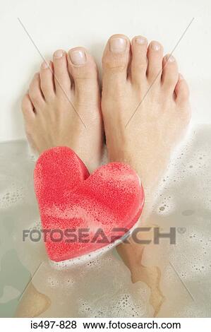 Feet and a heart shaped sponge in a bath View Large Photo Image Stock Photo - Feet and a heart shaped sponge in a bath. Fotosearch