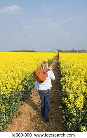 Woman in field with guitar View Large Photo Image Stock Image - Woman in field with guitar. Fotosearch