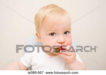 A baby boy eating a strawberry View Large Photo Image Stock Photo - A baby boy eating a strawberry. Fotosearch