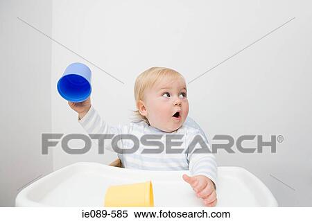 Stock Photography - A baby boy holding a cup. Fotosearch