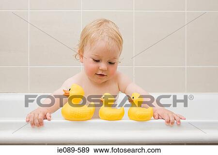 Stock Photo - A baby boy looking at a row of rubber ducks. Fotosearch