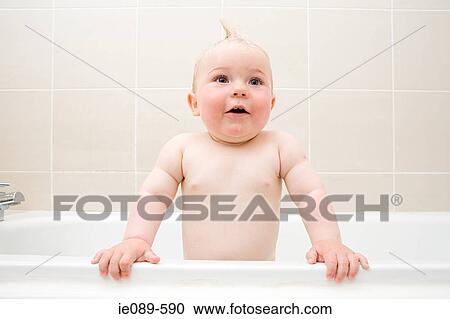 A baby boy standing in a bath View Large Photo Image Stock Image - A baby boy standing in a bath. Fotosearch