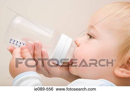 Stock Photograph - Baby boy drinking from bottle. Fotosearch