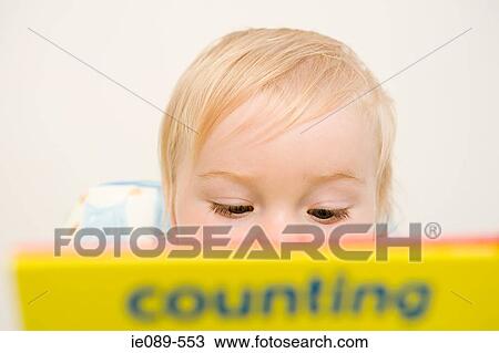 Baby boy looking at a book View Large Photo Image Stock Image - Baby boy looking at a book. Fotosearch