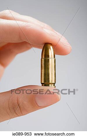 Person holding a bullet View Large Photo Image Stock Image - Person holding a bullet. Fotosearch