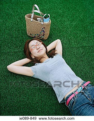 Young woman lying on artificial turf View Large Photo Image Stock Photo - Young woman lying on artificial turf. Fotosearch