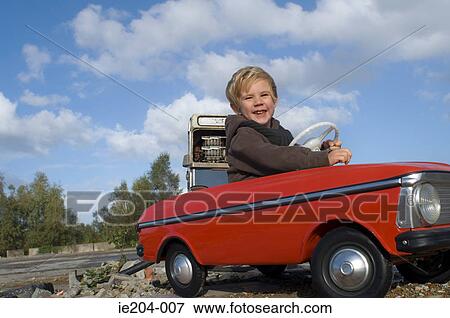 A boy in a toy car View Large Photo Image Stock Photo - A boy in a toy car. Fotosearch