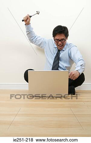 Stock Photo - A businessman holding a hammer. Fotosearch
