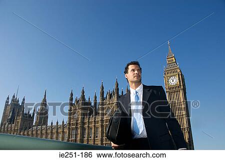 A businessman in front of the house of parliament View Large Photo Image Stock Photograph - A businessman in front of the house of parliament. Fotosearch