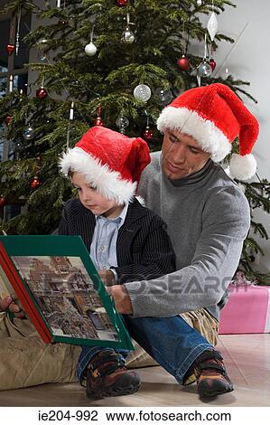 Stock Image - A father and son reading a book. Fotosearch