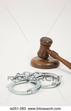 Stock Image - A gavel and handcuffs. Fotosearch